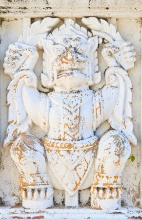 The old white garuda statue on wall in temple, Thailandの写真素材
