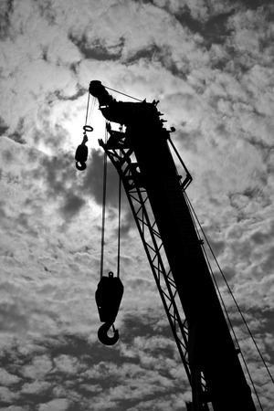 Black and white crane truck is working on sky backgroundの写真素材