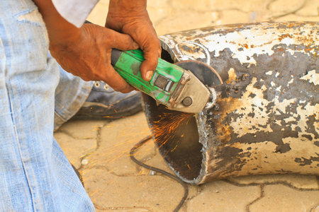 A man working with grinder. Close up on tool and handsの写真素材
