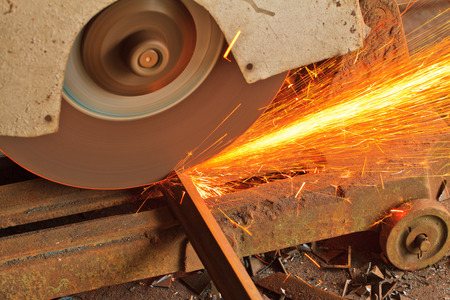 Close up a rotating circular saw is cutting a metalの写真素材