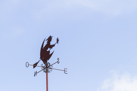 Witch weather vane on blue sky backgroundの写真素材