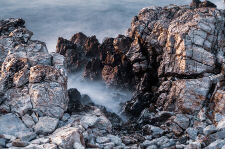 Beautiful stones, rocks and sea in a mystical haze at sunset. Long exposure. cool light landscape....