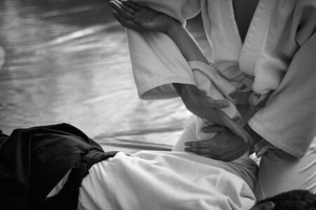 Black and white image of aikido. Hands of fighters. The traditional form of clothing in Aikido. Background image. No faces and recognizable elementsの写真素材