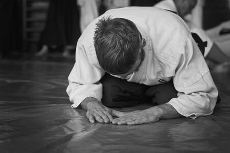 Black and white image of aikido. Athlete in the traditional form of Aikido. White kimano and black hakame. A bow as a sign of respect and welcome.の写真素材