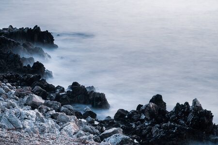 Beautiful stones, rocks and sea in a mystical haze at sunset. Long exposure. cool light landscape. Turkey. Aegean sea shore.の写真素材