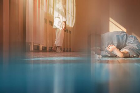 Sports background with blur. Kids training on karate-do. Young athletes karatekas do warm-up and stretching in the gym on a wooden floor. Photo without faces.の写真素材