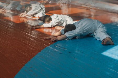Warm up before training the karate-do children's group. Young athletes in traditionally white kimonos. Banner with space for text. Retro style. For web pages or advertising printing. Photo without faces.の写真素材
