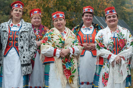 Belarus, urban village Glusha - October 5, 2019. Women in Belarusian folk costumes. Embroidered dresses and painted scarves. Traditional autumn harvest festival. People and traditions.のeditorial素材