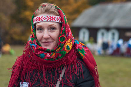 Belarus, urban village Glusha - October 5, 2019. Portet of a casual young woman in a folk costume. Participant in the national autumn harvest festival.のeditorial素材