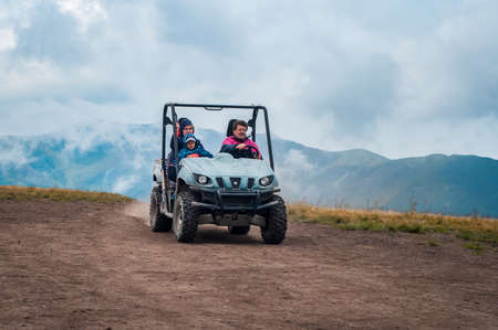 Ukraine, Carpathian Mountains - July 20, 2019. Random people in a car, quadro cycle, ride on the road to the top of Ghimba Mountain in the Carpathians. The family is traveling.のeditorial素材