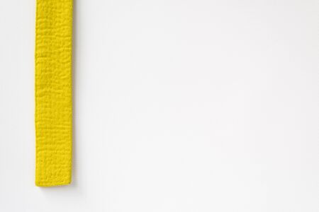 Zen art. Yellow belt martial arts on white background. Substrate for diplomas, posters, sites on aikido, karate, judo. Copy paste.の写真素材