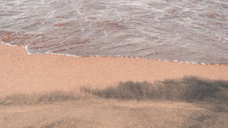 Transparent sea waves on the warm sandy seashore. Sea vacation and travel.