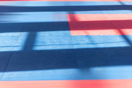 Sports background. Red-blue colors of traditional soft floor covering for karate, taekwono practice.の写真素材