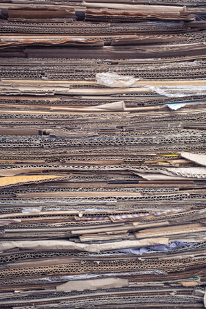 Used corrugated paper in a pile. Collection of waste paper. Waste recycling and environmental preservation.の写真素材