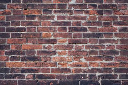 Brick old wall of dark red color. Horizontal vintage background. Exterior.
