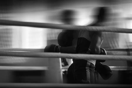 Black and white silhouettes of boxing athletes in the ring. Combat sports. Shallow depth of field, focus on the hands of athletes.の写真素材