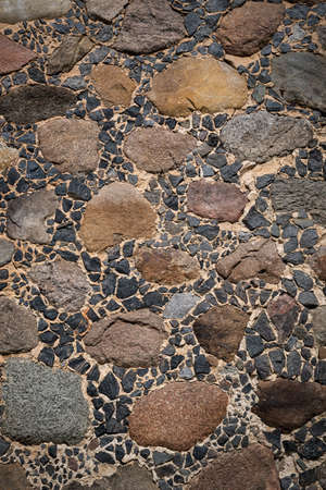 The stone wall of the Orthodox Church from large cobblestones and small stones.