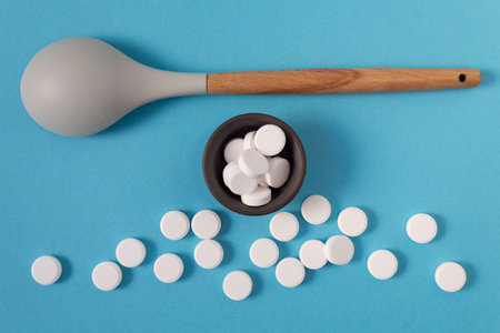 White large vitamin tablets on a pale blue background. medicine and health.の写真素材
