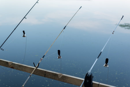 Fishing rod with a stretched fishing line and bells on the background of the water. Background on...