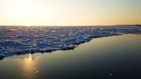 Sunset reflection in iced water. Beautiful natural landscape.