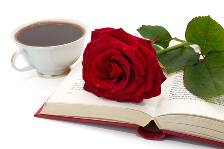 Open book with beautiful red rose and cup of coffee on white background の写真素材