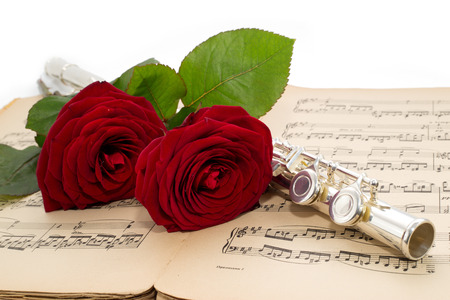 Silver flute and beautiful red rose on an ancient musical の写真素材