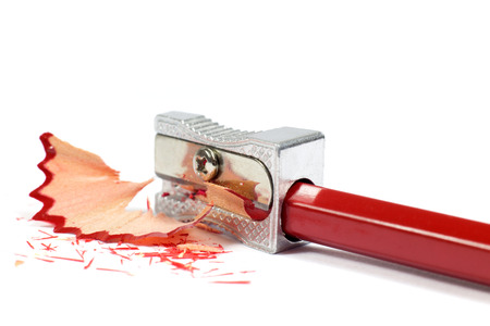 Macro Shot of Metallic Pencil Sharpener Sharpening Red Pencil Isolated on White Backgroundの写真素材