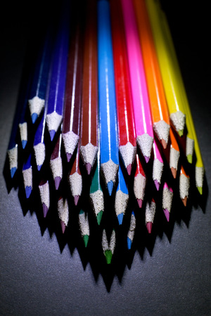Macro Shot of Sharpened Colorful Pencils Against Black Background. Instruments for writing or drawing, consisting of a thin stick of graphite enclosed in a long thin piece of woodの写真素材