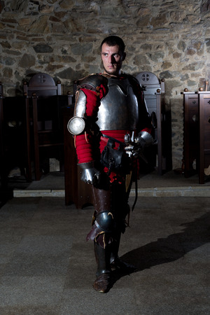 Full Length Portrait of Knight in Armor Standing in Old Monasteryの写真素材
