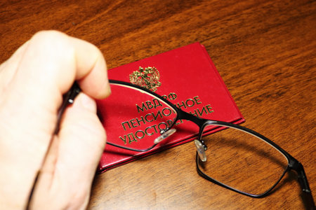Pension certificate of the Ministry of Internal Affairs of Russia, glasses in hand, table, dark...