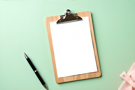 Clipboard with blank paper on green background. Copy space.
