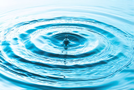 drop of water on a blue background with waves and ripples.の写真素材