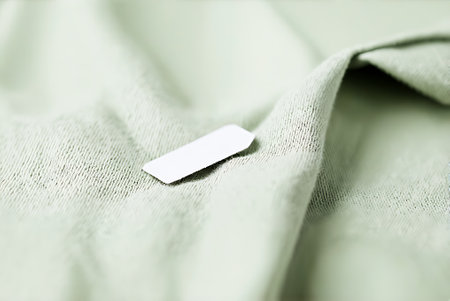 Blank white business card on green fabric background. Selective focus.の写真素材