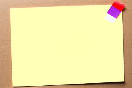 Yellow note paper with adhesive tape on wood background with copy space.