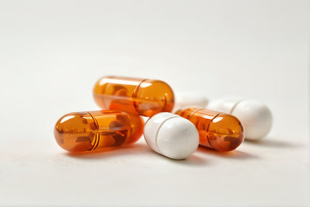 Orange capsules on a white background. Focus on foreground, soft bokeh.