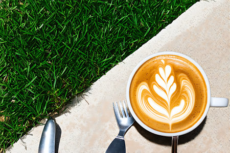 Cup of latte art coffee on green grass background, top viewの写真素材