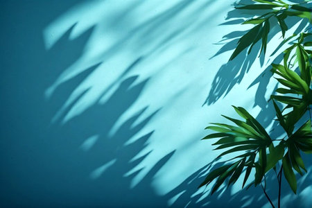 Tropical palm leaves shadow on blue wall background. Minimal summer concept.