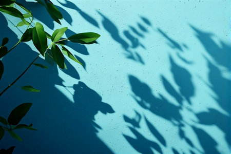 Shadow of leaves on a blue wall. Natural background. Copy space.