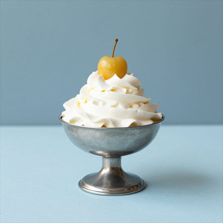 Vanilla ice cream with cherry in metal bowl on blue background.