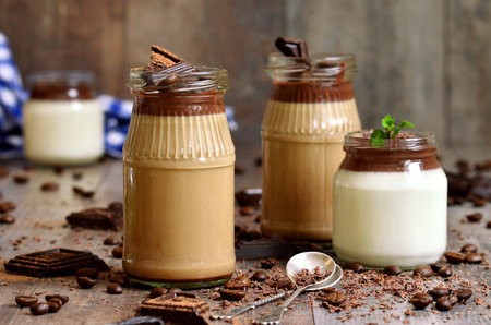 Pannacotta in a jar in two variations on wooden table.の写真素材