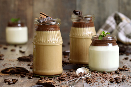 Pannacotta in a jar in two variations on wooden table.の写真素材