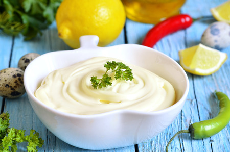 Homemade mayonnnaise in a white bowl on a blue wooden table.の写真素材