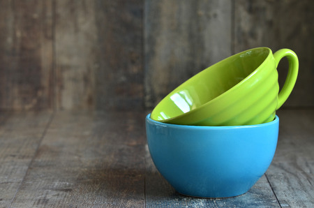 Multicolored ceramic bowl on a wooden table.の写真素材