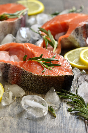 Raw trout with ice cubes on a wooden table.の写真素材