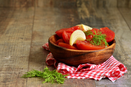 Homemade marinated tomatoes in a wooden bowl.の写真素材