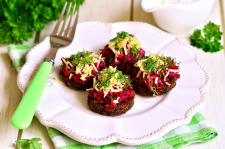 Spicy canape from fried rye bread with beetroot,carrot,garlic and cheese.の写真素材