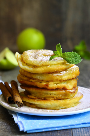 Apples fried in a batter on wooden table.の写真素材