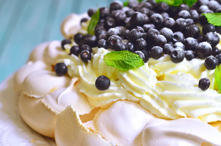 Cake "Pavlova" with blueberry and mascarpone on a white plate.Toned photo.の写真素材