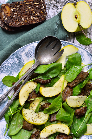 Baby spinach salad with beef liver and apple on vintage plate.Top view.の写真素材