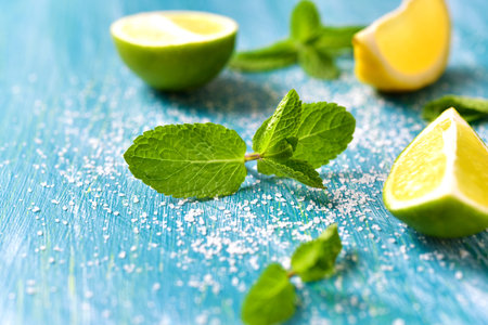 Lime and mint leaves on a blue wooden background.